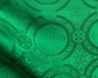 Könnte beinhalten: Grüner Stoff mit einem sich wiederholenden Muster aus einem Kreuz in einem Kreis. Der Stoff hat eine subtile Textur und eine leicht glänzende Oberfläche.