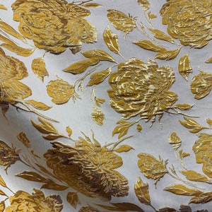 May include: White fabric with a gold floral pattern. The fabric features a repeating design of large, stylized peonies with leaves and stems.