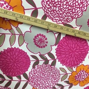 May include: White fabric with a pink, orange, and gray floral pattern. The fabric features large, stylized flowers with a repeating pattern.