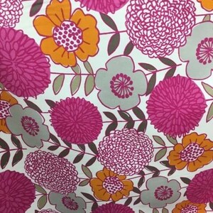 May include: A white fabric with a floral pattern featuring pink, orange, and gray flowers. The flowers are stylized and have a vintage look.