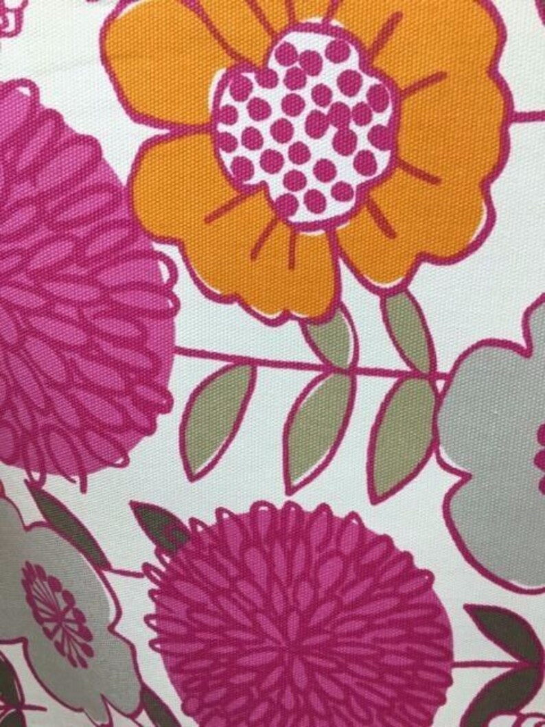 May include: White fabric with a floral pattern featuring pink, orange, and gray flowers. The flowers are stylized and have a retro look.