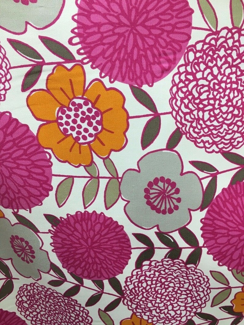 May include: A white fabric with a floral pattern. The flowers are pink, orange, and gray. The background is white.