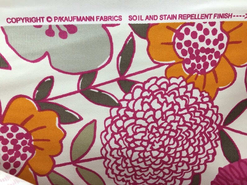 May include: White fabric with a floral pattern in shades of pink, orange, and gray. The fabric has a soil and stain repellent finish. The text "COPYRIGHT &copy; P.KAUFMANN FABRICS" is visible at the top of the image.
