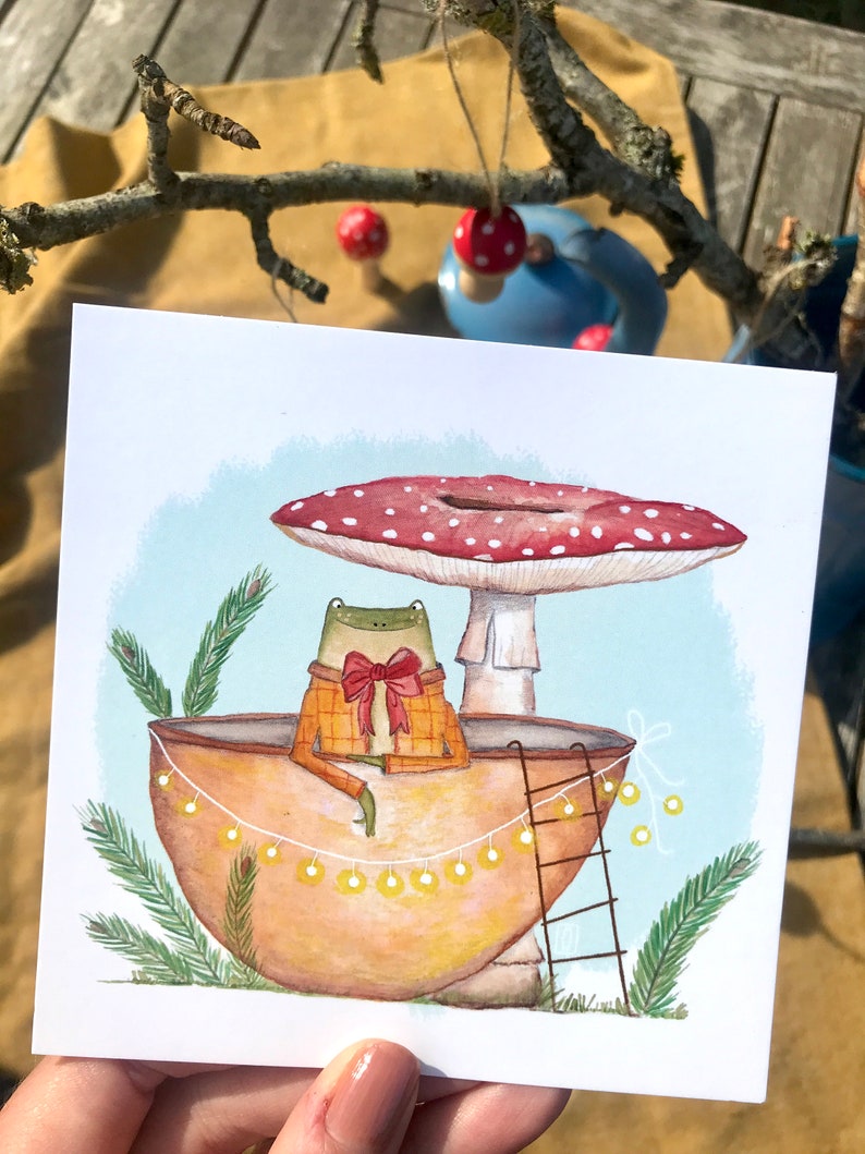 Petite grenouille mignonne dans sa coquille de noix sous son champignon jolie carte peinte à l'aquarelle et reproduite sur du papier épais de très bonne qualité