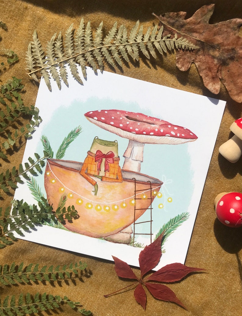 Petite grenouille mignonne dans sa coquille de noix sous son champignon jolie carte peinte à l'aquarelle et reproduite sur du papier épais de très bonne qualité