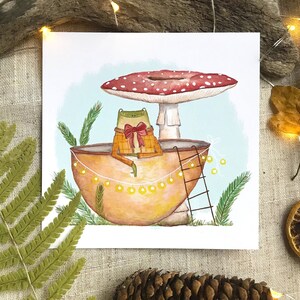 Petite grenouille mignonne dans sa coquille de noix sous son champignon jolie carte peinte à l'aquarelle et reproduite sur du papier épais de très bonne qualité
