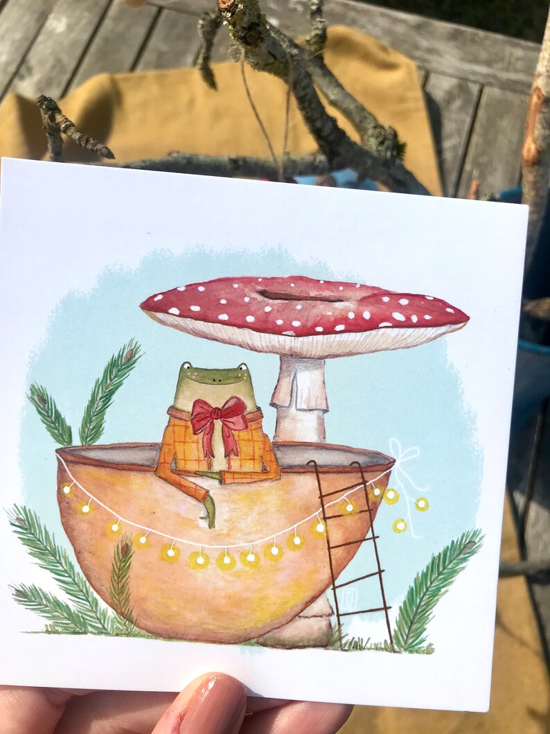 Petite grenouille mignonne dans sa coquille de noix sous son champignon jolie carte peinte à l'aquarelle et reproduite sur du papier épais de très bonne qualité