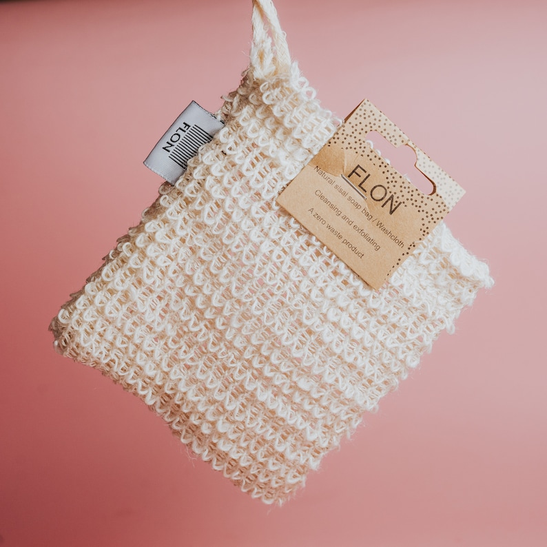 Pode incluir: Um saco de sab&atilde;o de sisal natural branco ou uma toalha com uma etiqueta de papel castanho que diz "FLON Saco de sab&atilde;o de sisal natural/Toalha de lavagem Limpeza e esfolia&ccedil;&atilde;o Um produto zero desperd&iacute;cio".