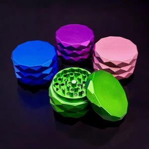 May include: Four multi-colored metal grinders with a diamond-shaped design. The grinders are in shades of pink, blue, purple, and green. One of the grinders is open, revealing the grinding mechanism.