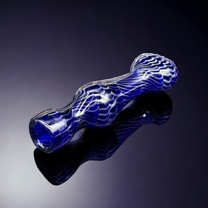May include: A blue glass pipe with white swirling patterns. The pipe has a curved shape with a wider bowl at one end and a narrower mouthpiece at the other. The glass is reflective, and the pipe is set against a dark background.