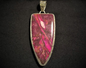 May include: A silver pendant with a large, pink and brown agate stone in a shield shape.