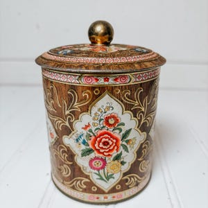Recipiente de hojalata vintage Daher con tapa y diseño floral, fabricado en Inglaterra.