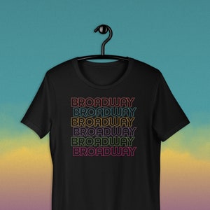 May include: Black t-shirt with the word "BROADWAY" repeated six times in a rainbow gradient.