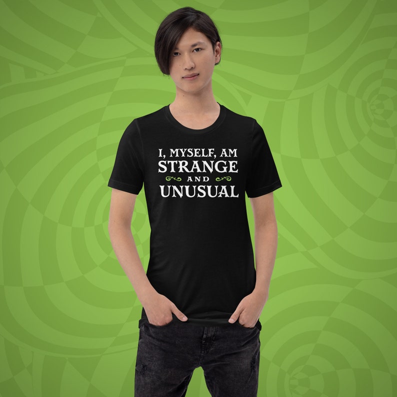 May include: A black t-shirt with white text that reads "I, myself, am strange and unusual".