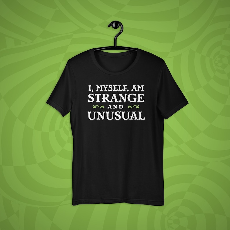 May include: Black t-shirt with white text that reads "I, myself, am strange and unusual".