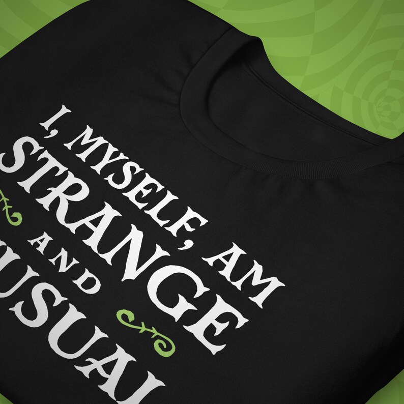 May include: Black t-shirt with white text that reads "I, Myself, Am Strange And Usual".