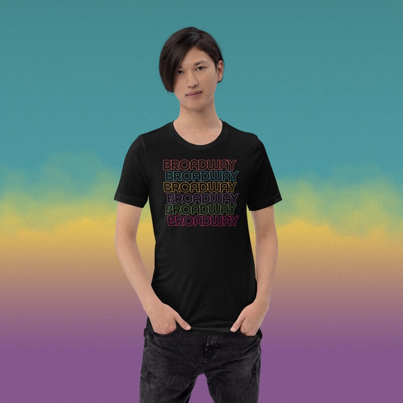 May include: A black t-shirt with a retro-style graphic design featuring the word "BROADWAY" repeated five times in different colours.