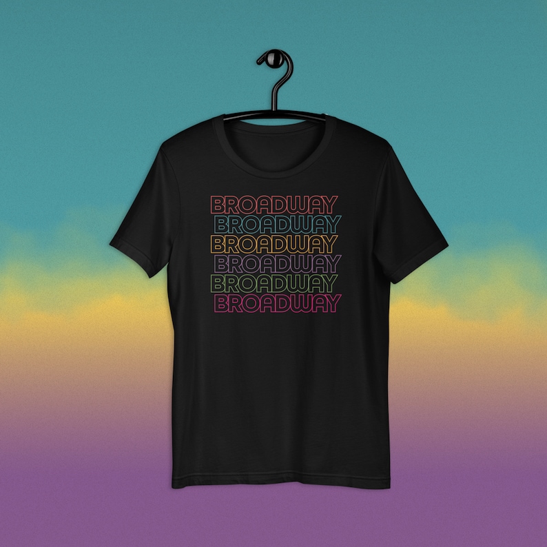 May include: Black t-shirt with the word "BROADWAY" repeated six times in a rainbow gradient.