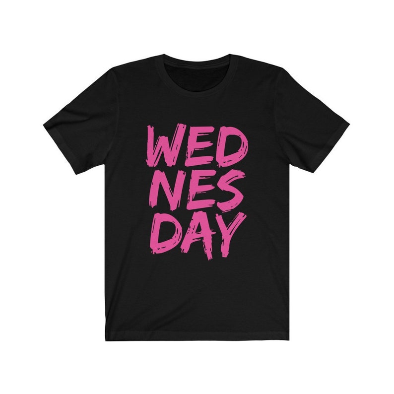 Puede incluir: Camiseta negra con las palabras "WEDNES DAY" escritas en rosa.