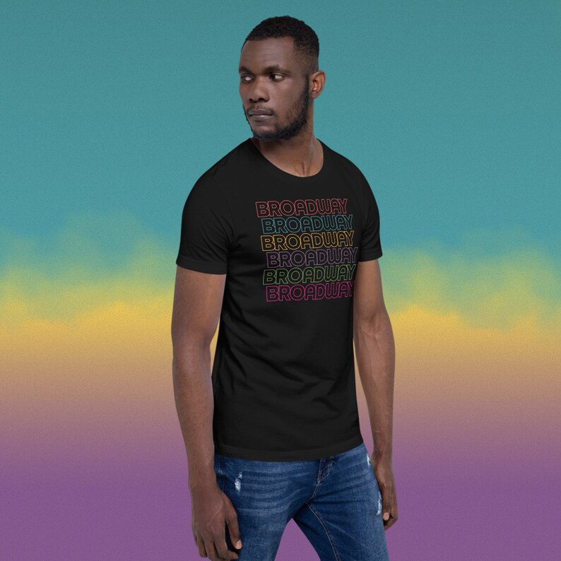 May include: A black t-shirt with the word "BROADWAY" repeated in a rainbow gradient pattern.