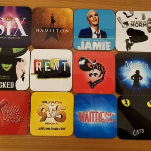 May include: A collection of 16 square coasters featuring various Broadway musical logos. The coasters are made of a hard, glossy material and feature colorful designs. Some of the musicals featured include Dear Evan Hansen, Six, Hamilton, The Book of Mormon, Heathers, Les Miserables, Wicked, Rent, Kinky Boots, 9 to 5, Waitress, Cats, The Phantom of the Opera, Matilda, Rock of Ages, and Joseph and the Amazing Technicolor Dreamcoat.