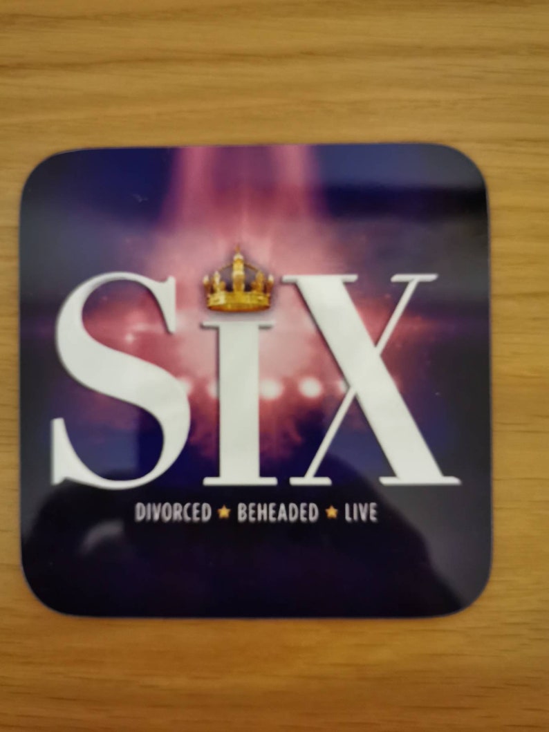 May include: A purple and white coaster with the word "SIX" in large white letters and a gold crown above the word. The text "DIVORCED  BEHEADED  LIVE" is below the word "SIX".