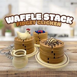 May include: A collection of waffle-shaped fidget clickers with various toppings, including a chicken, blueberries, and chocolate drizzle. The words "WAFFLE STACK FIDGET CLICKER" are displayed in a brown font. A small pitcher is also included.