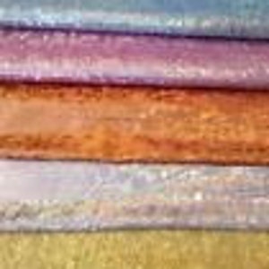 May include: Five rolls of iridescent fabric in different colors: light blue, purple, orange, lavender, and gold.