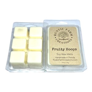 May include: A six-pack of soy wax melts in a clear plastic container. The wax melts are a light yellow color. The label on the container reads "Rustic Farm Creations" and "Fruity Hoops". The label also states that the wax melts are handmade in Florida and are 2.5 oz (70g).