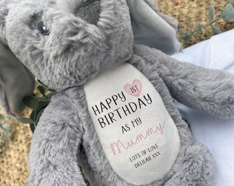 May include: A plush gray bunny rabbit with long ears. The bunny has a white patch on its chest with the text "Happy 1st Birthday as my Mummy" and "Lots of Love Delilah XXX" in black and pink script.