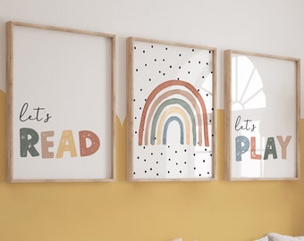 May include: Three framed art prints with wooden frames. The prints feature the phrases "let's READ" and "let's PLAY" in colorful letters, and a rainbow design. The prints are displayed above a wooden bench with pillows and storage bins.