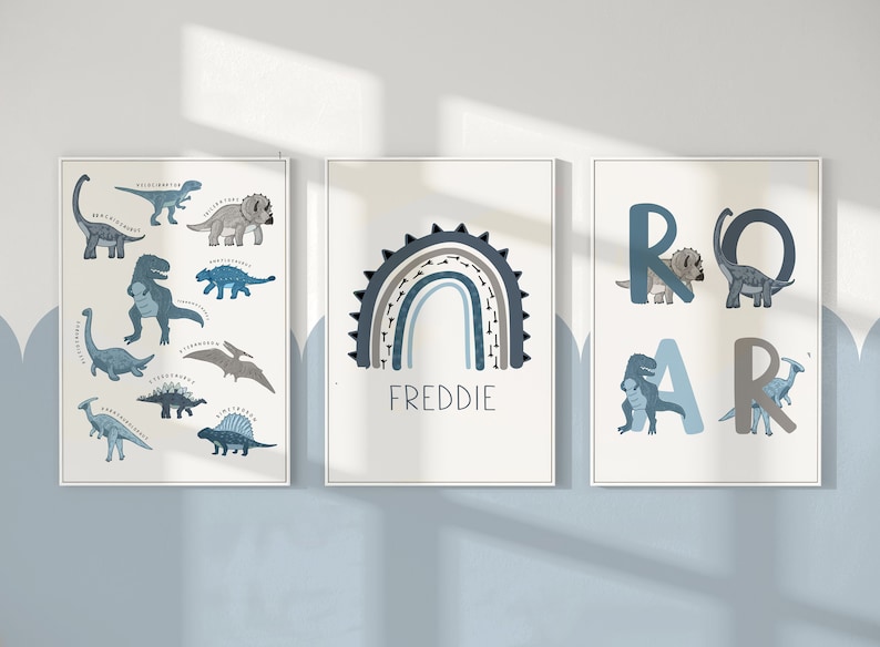 May include: Three framed dinosaur-themed art prints. One features various dinosaur illustrations with their names. Another displays a rainbow with the name "FREDDIE". The third spells "ROAR" with dinosaur illustrations.