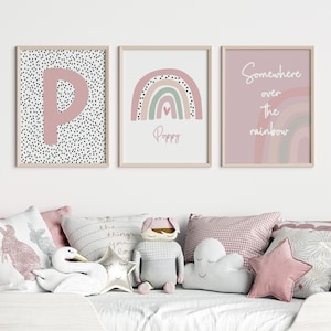 May include: Three framed art prints with a nursery theme. One features a pink letter "P" on a black and white polka dot background. Another displays a rainbow with the name "Poppy". The third says "Somewhere over the rainbow".