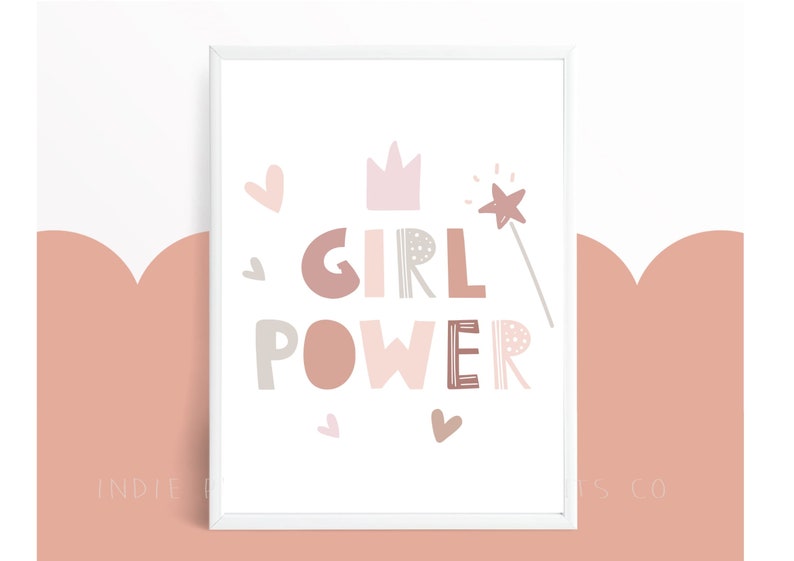 May include: A framed print with the words "GIRL POWER" in various shades of pink, brown, and gray. The design includes a crown, hearts, and a star-tipped wand. The background is white with a pink and white scalloped design.