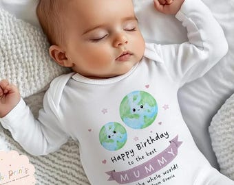 May include: A sleeping baby wearing a white onesie with long sleeves. The onesie features two cartoon globes and the text "Happy Birthday to the best MUMMY in the whole world! Love from Gracie."