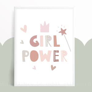 May include: A framed print with the words "GIRL POWER" in various shades of pink and brown. The design includes a crown, hearts, and a star-tipped wand. The background is white with a light green scalloped design.