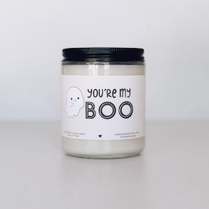 Op de afbeelding: Een glazen potkaars met een zwarte deksel. Het etiket toont een cartoon spookje en de tekst "You're my BOO" in het zwart. De kaars is gevuld met witte was. Een leuk cadeau voor Halloween.