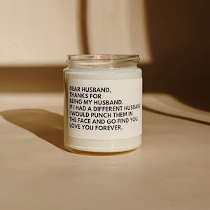 Könnte beinhalten: Ein Glas-Kerzenglas mit einem weißen Etikett mit schwarzem Text. Der Text lautet: "LIEBER EHEMANN, DANKE, DASS DU MEIN EHEMANN BIST. WÄRE ICH MIT EINEM ANDEREN MANN VERHEIRATET, WÜRDE ICH IHN INS GESICHT SCHLAGEN UND DICH SUCHEN. LIEBE DICH FÜR IMMER."