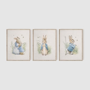 May include: Three framed prints featuring illustrations of Peter Rabbit. The first print shows Peter Rabbit hugging a smaller rabbit. The second print shows Peter Rabbit standing with his hands clasped in front of him. The third print shows Peter Rabbit walking away from the viewer.