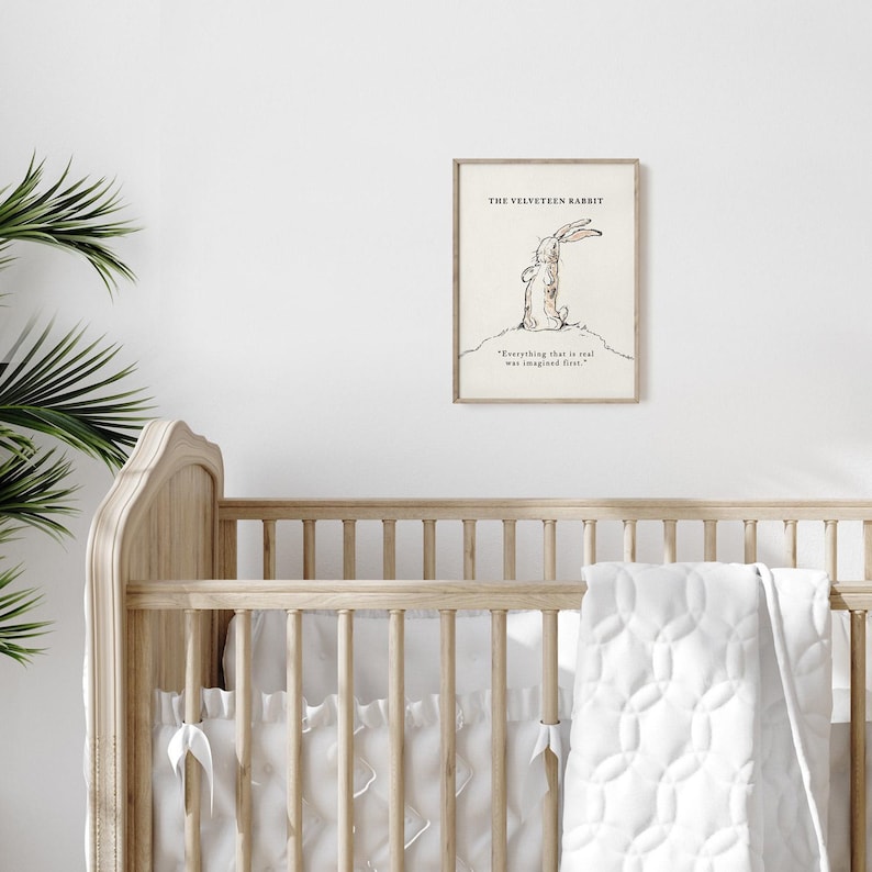 May include: A framed print of "The Velveteen Rabbit" illustration. The artwork features a sketch of a rabbit with the quote "Everything that is real was imagined first." The print is displayed above a wooden crib.