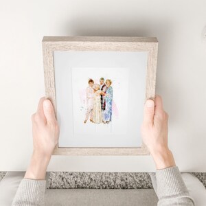 Op de afbeelding: Een ingelijst aquarelprint van vier vrouwen die samen in een groep staan. De vrouwen dragen kleurrijke kleding en lachen. De achtergrond is een zachte roze aquarelwas.