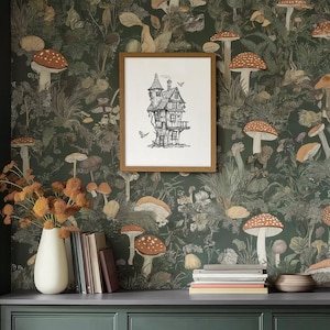 May include: A framed print of a black and white illustration of a house with a chimney and a pointed roof. The house is surrounded by a forest of mushrooms and plants. The print is hanging on a wall with a dark green wallpaper featuring a repeating pattern of mushrooms and plants.
