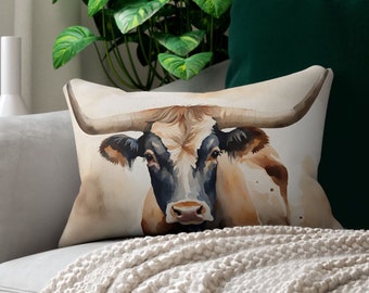 Puede incluir: Una pintura de acuarela de un toro Longhorn marrón y blanco con grandes cuernos. El toro está mirando directamente al espectador con una expresión seria. La pintura está sobre un fondo blanco.