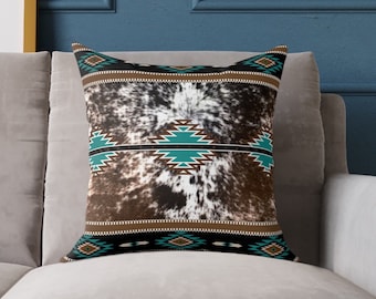 May include: A decorative throw pillow with a brown and white cowhide pattern and turquoise and black geometric designs.