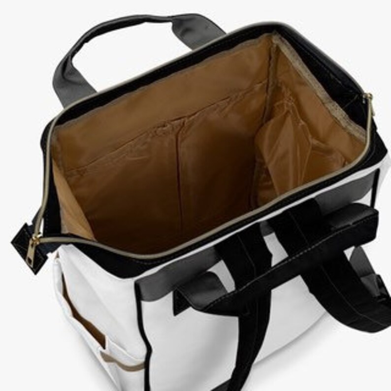 May include: White and black backpack with a large main compartment and several smaller pockets. The backpack has a zipper closure and adjustable straps.