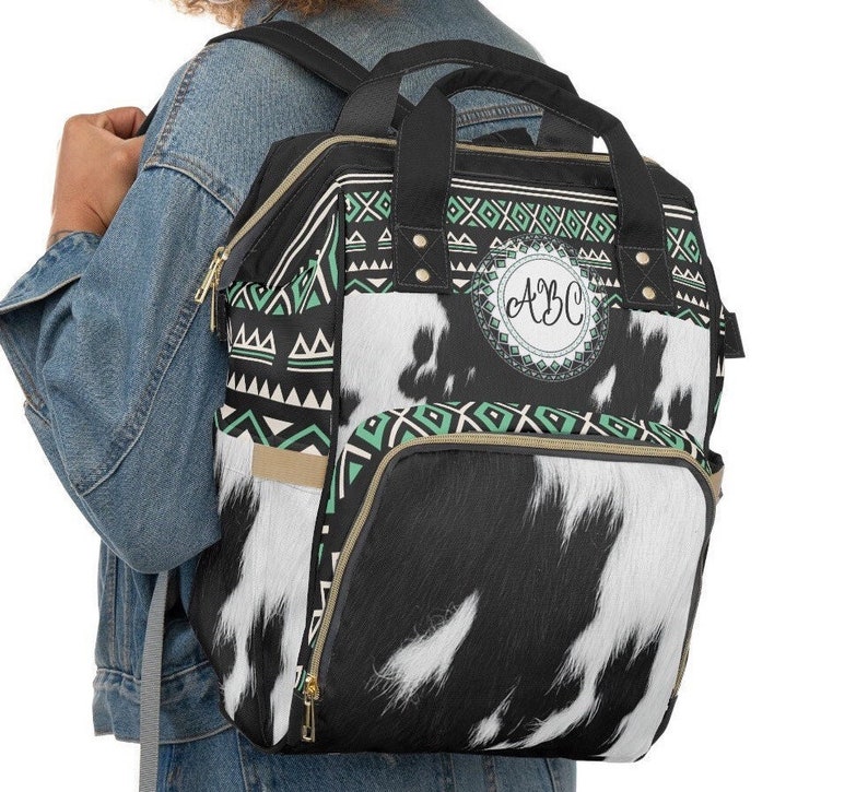 Personalized Black and white faux cowhide turquoise boho western style diaper bag backpack. Custom Monogrammed with your name or initials.