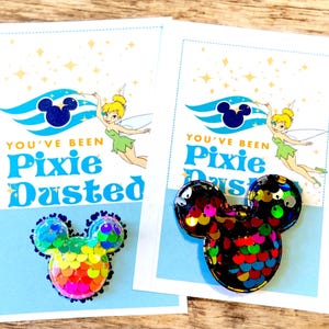 May include: Two cards with a Disney theme. Each card has a Mickey Mouse sequin design and the text "You've Been Pixie Dusted". The cards feature a blue background with Tinkerbell and a Mickey Mouse silhouette.