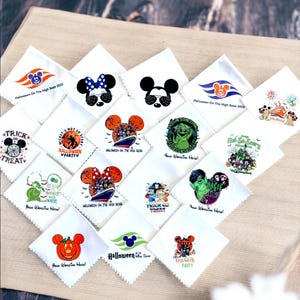 May include: A collection of white handkerchiefs with various Halloween-themed designs. The handkerchiefs feature images of Mickey and Minnie Mouse, pumpkins, and text like "Trick or Treat" and "Halloween Party."