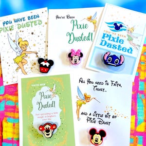May include: Cards with the text "You Have Been Pixie Dusted!" and "All You Need is Faith, Trust..." are displayed with character-shaped pins. The pins feature Mickey Mouse, Minnie Mouse, Stitch, and Tigger.