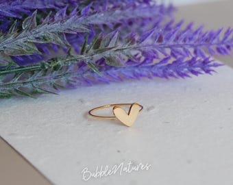 May include: A delicate gold ring featuring a heart-shaped design. The ring is set against a backdrop of purple lavender and a white surface. The text "BubbleNatures" is visible in the lower part of the image.
